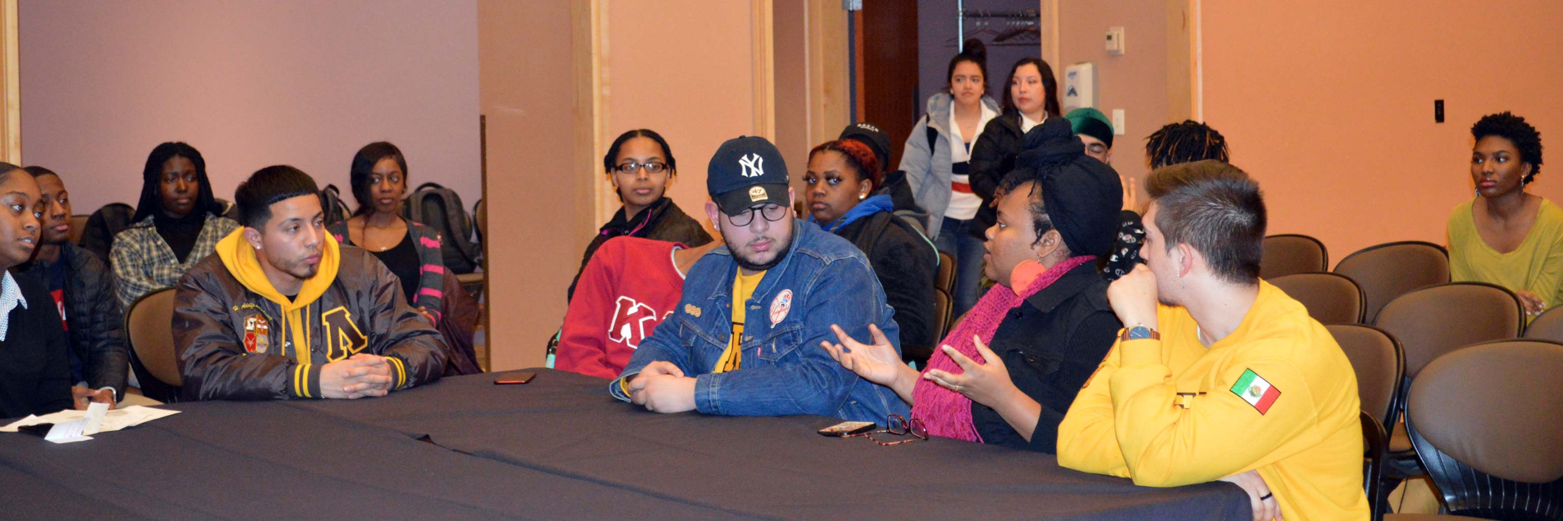 A group of students having a discussion around a table.