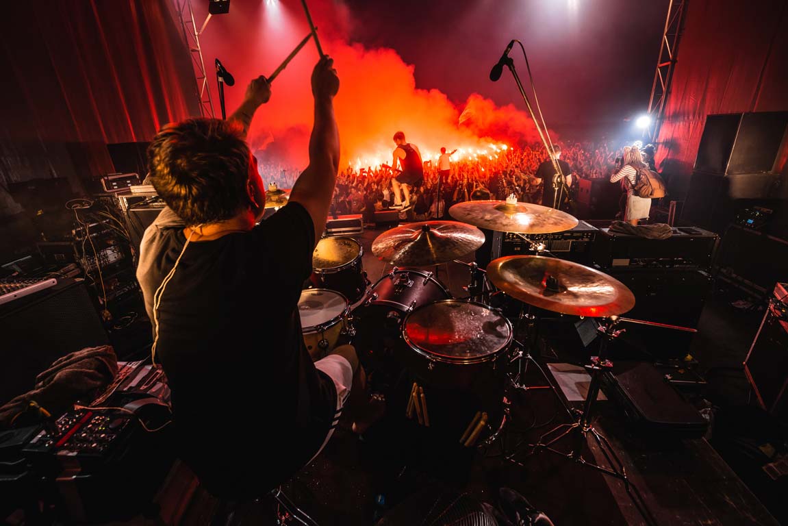 A punk band performing in front of a live audience